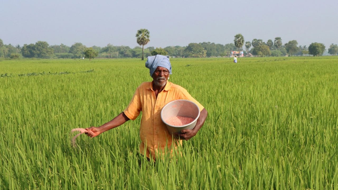 शेतकरी शेतात काम करत असताना MahaDBT Farmer योजनेची माहिती घेत असलेला